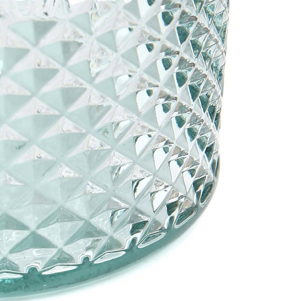 Close-up of a crystal glass with diamond cut pattern on a white background