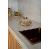 Bathroom vanity with concrete countertop and wooden sink.