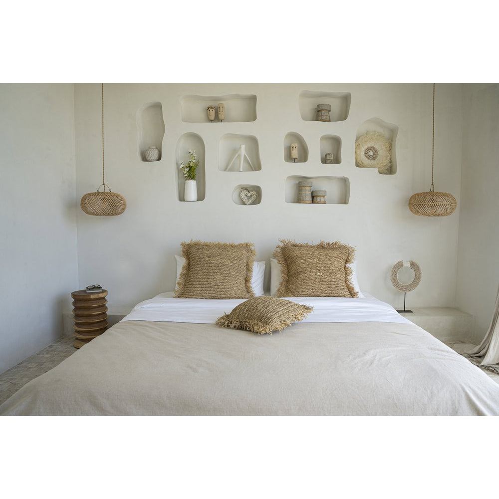 Bedroom with a bed, pillows, and decorative wall shelves.