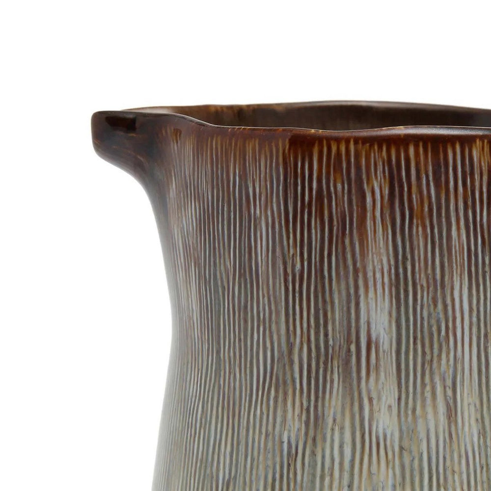 Close-up of a ceramic pitcher with textured surface on a white background