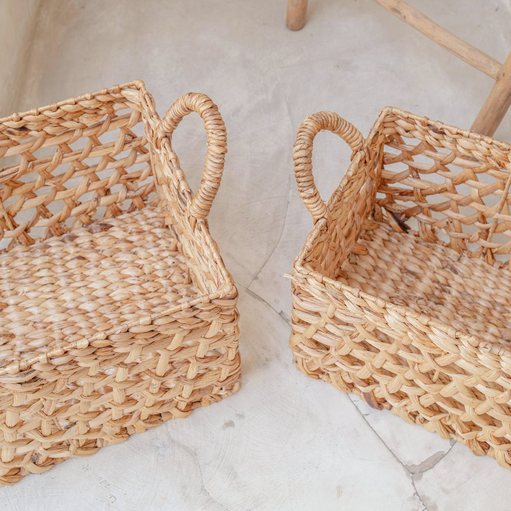 Two woven baskets on a light stone surface