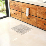 Wooden kitchen cabinets with a towel hanging on a rack, floor vent in the foreground.