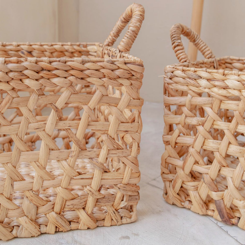 Two woven baskets on a light surface with a neutral background