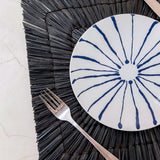 Black seagrass placemat with radial woven pattern