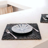 Black seagrass placemat with radial woven pattern