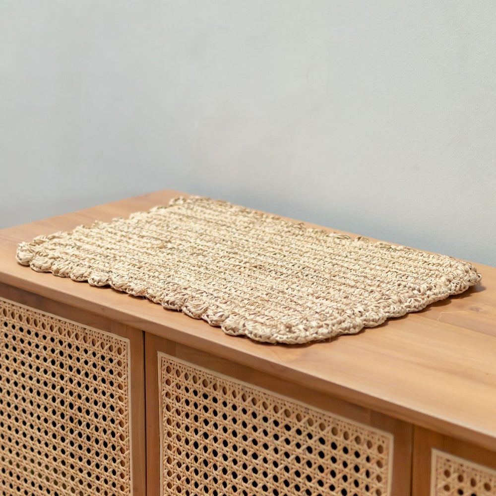 Woven mat on a wooden surface with a neutral background
