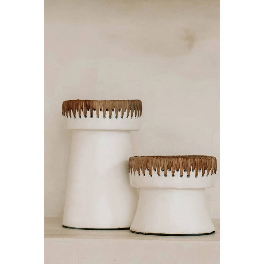 Two white cylindrical stools with wooden top accents on a neutral background