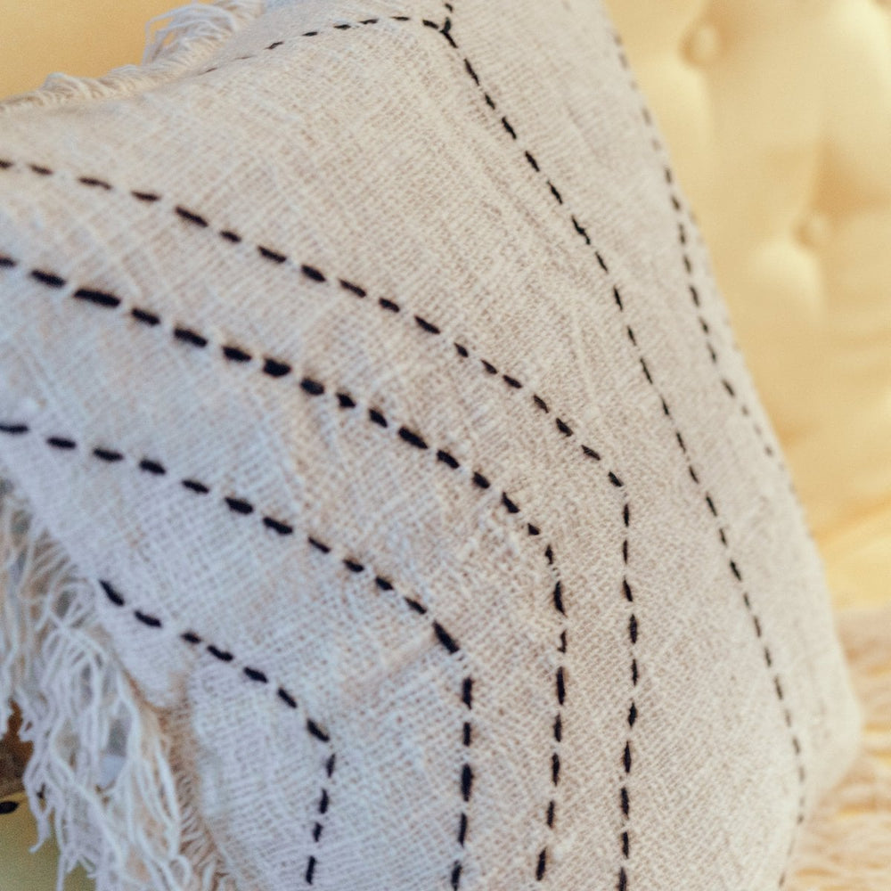 Close-up of a textured fabric with stitching details on a blurred background
