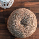 Round woven ottoman on a wooden floor