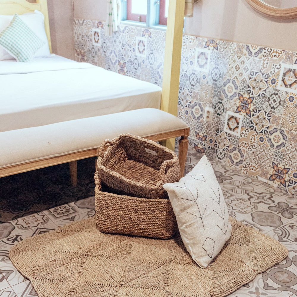 Bedroom with woven baskets, rug, and patterned wall tiles.