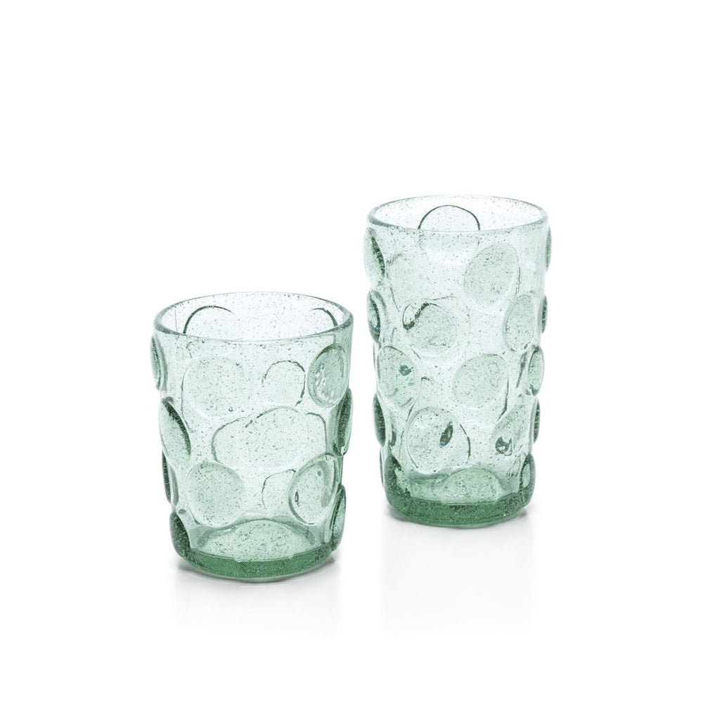 Two green glass tumblers with textured design on a white background