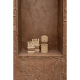 Sandstone statue with cowrie shells and jute wrap