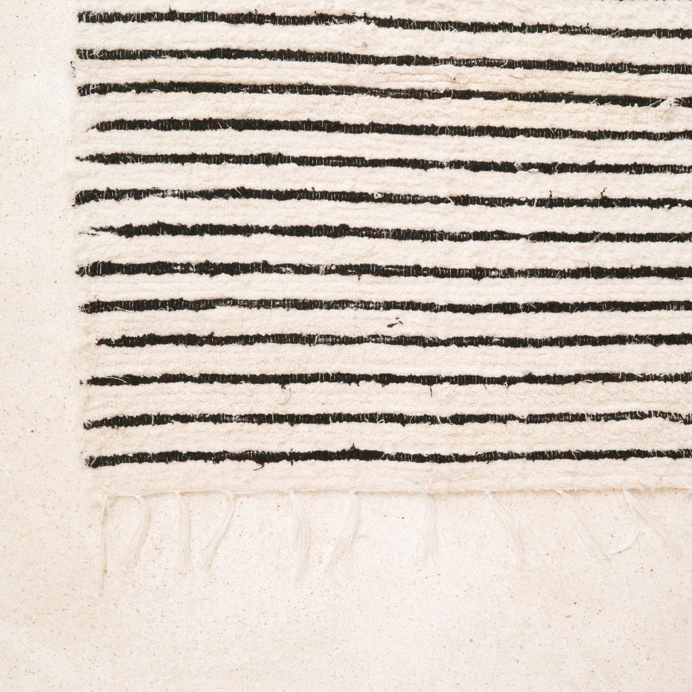 Textured fabric with black and white stripes on a beige background