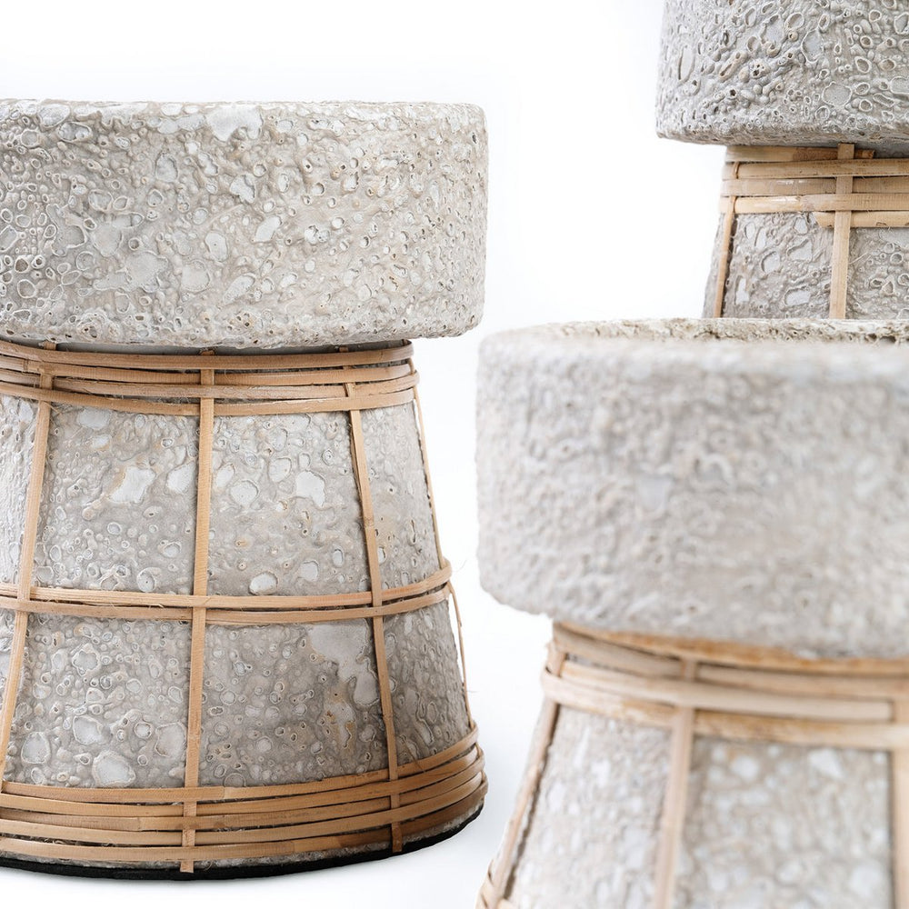 Concrete stools with woven rattan bases on a white background