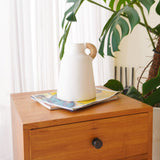 White clay vase with rattan-wrapped handle