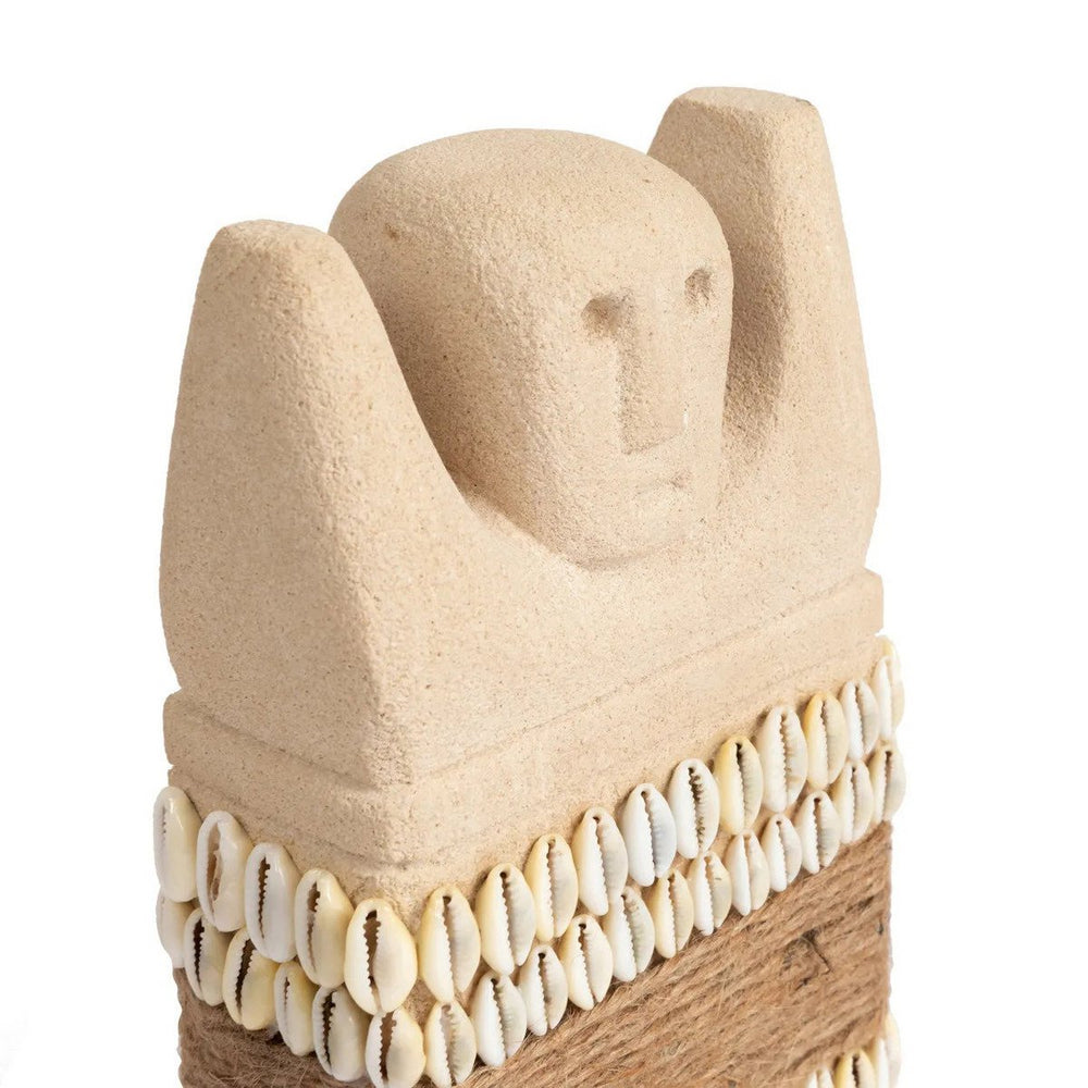 Sandstone statue with cowrie shells and jute wrap