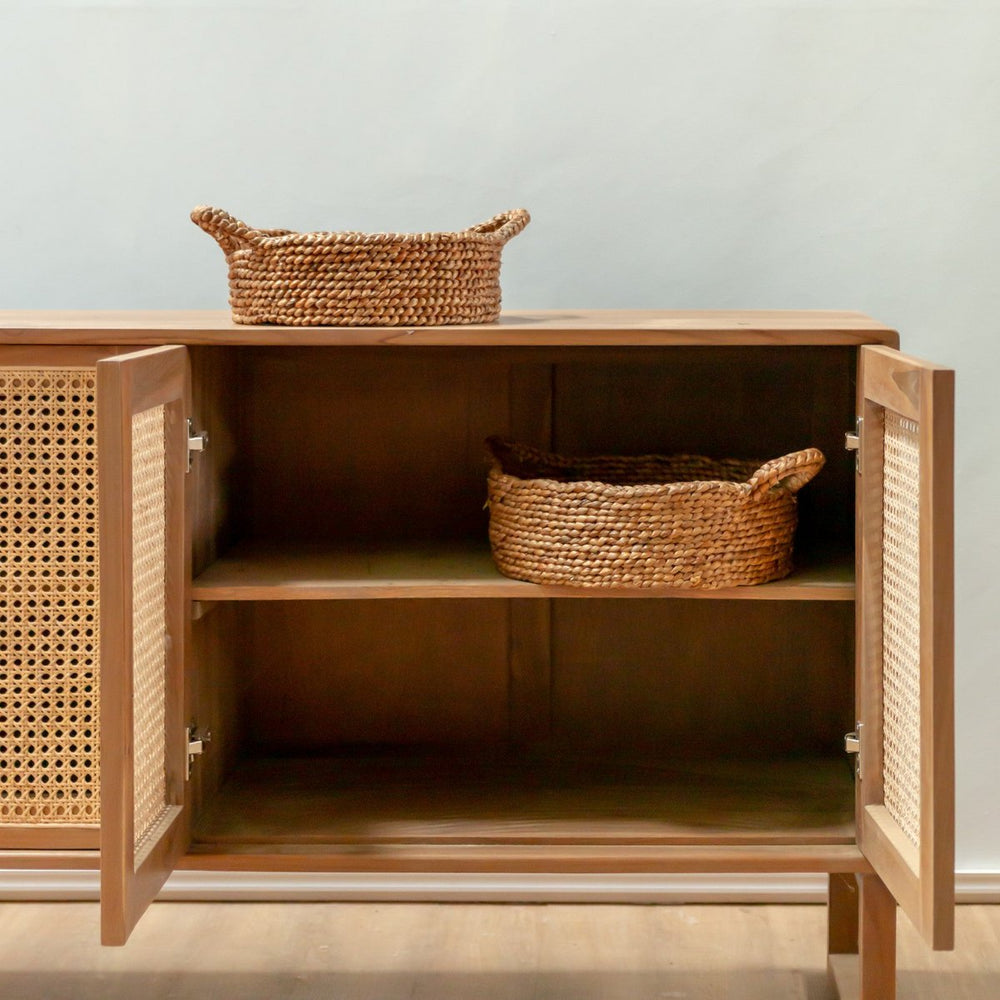 Wooden cabinet with wicker baskets on a light background