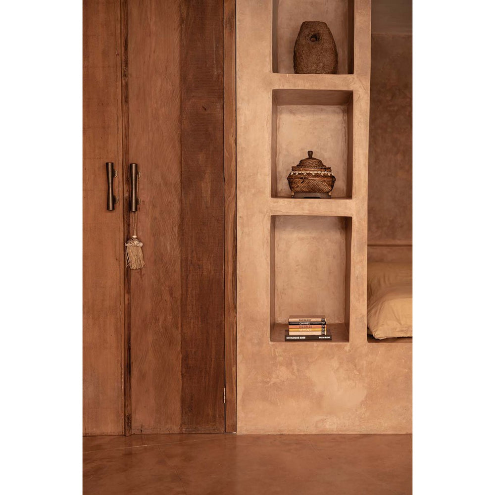 Wooden wardrobe with open door revealing shelves inside a room.