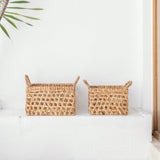 Two wicker baskets on a white surface with a light background