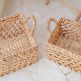 Two woven baskets on a light stone surface