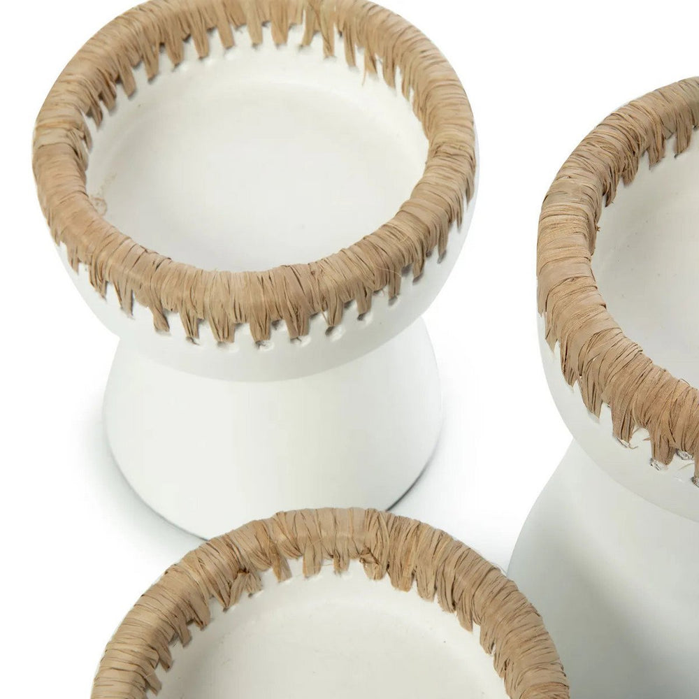 Three white planters with beige woven rims on a white background
