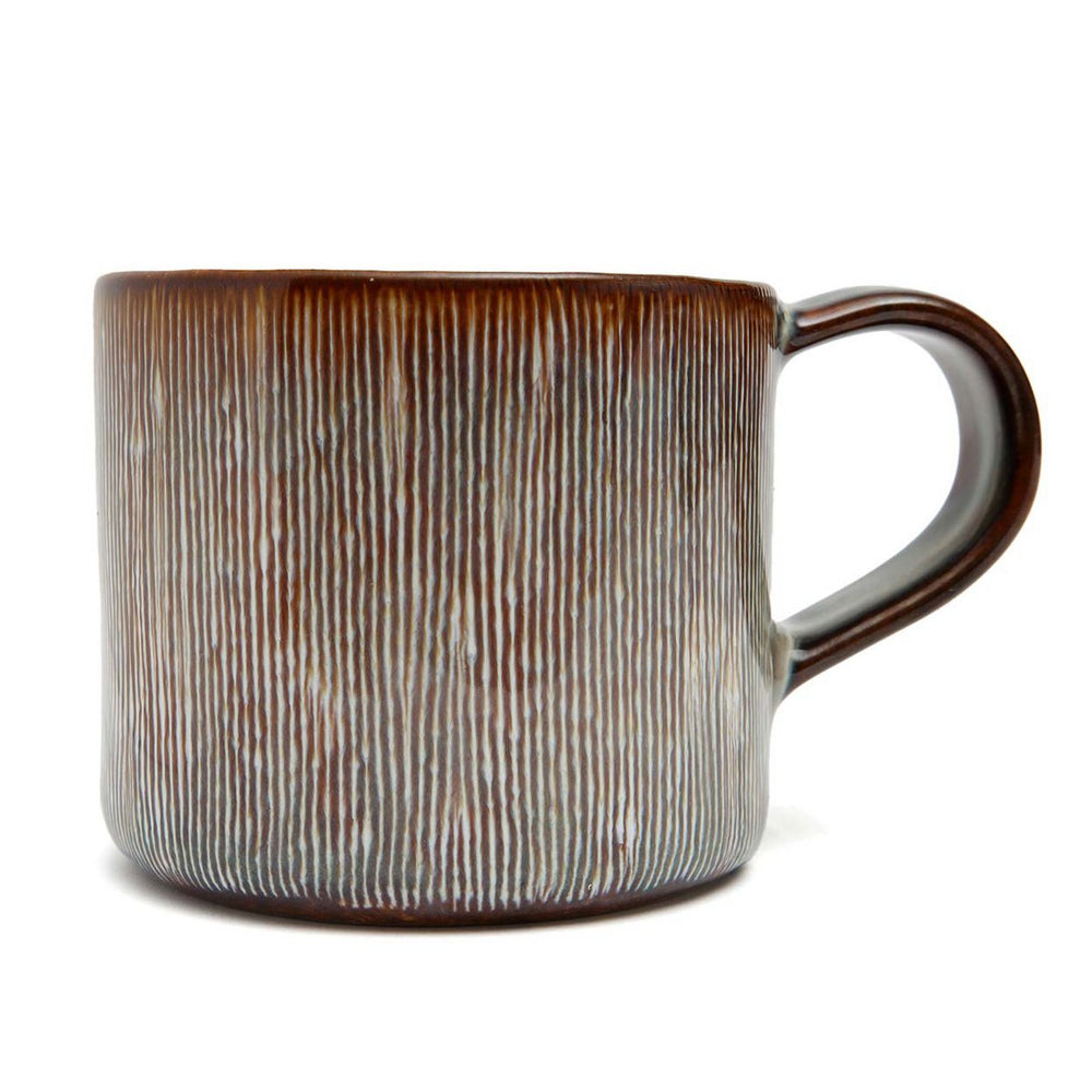 Brown ceramic mug with textured surface on a white background