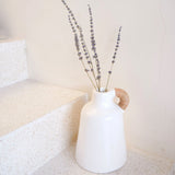 White clay vase with rattan-wrapped handle