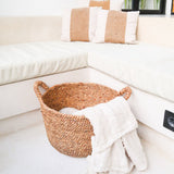 Woven basket with a blanket on a white sofa