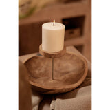 White candle on a wooden stand with a blurred background