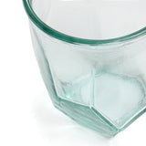 Hexagonal glass container with a green rim on a white background