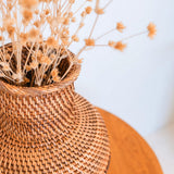 Woven basket with dried flowers on a light background