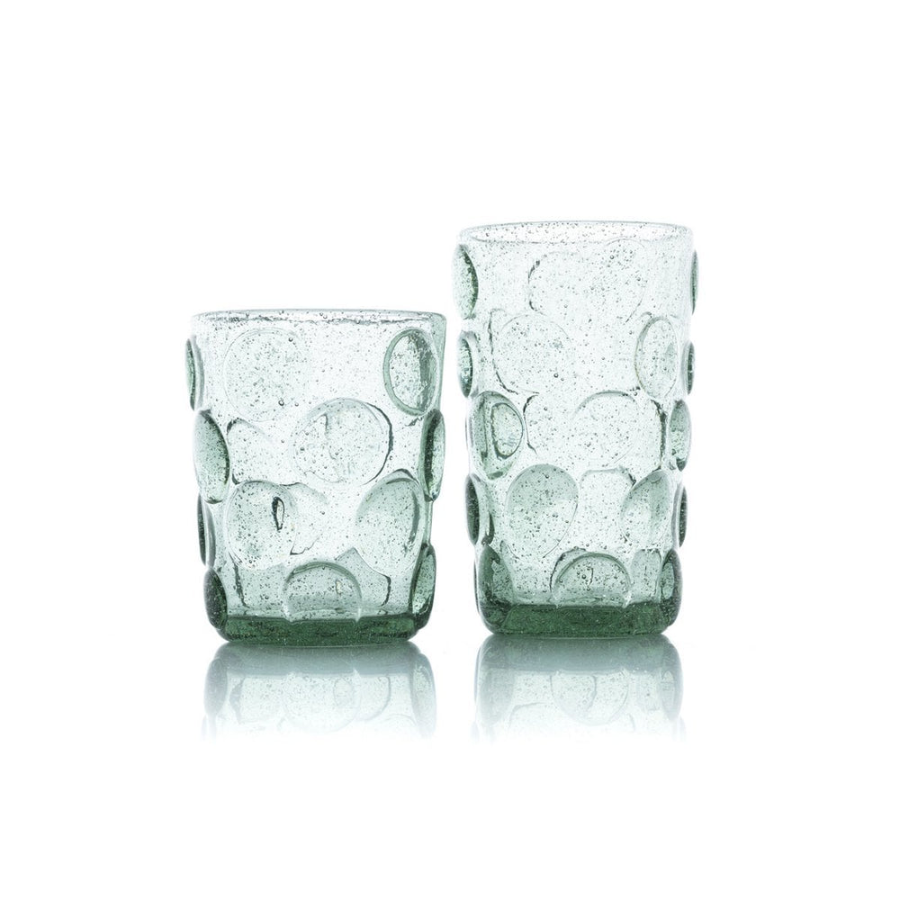 Two green glass tumblers with bubble design on a white background