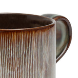 Close-up of a brown ceramic mug with a textured surface on a white background