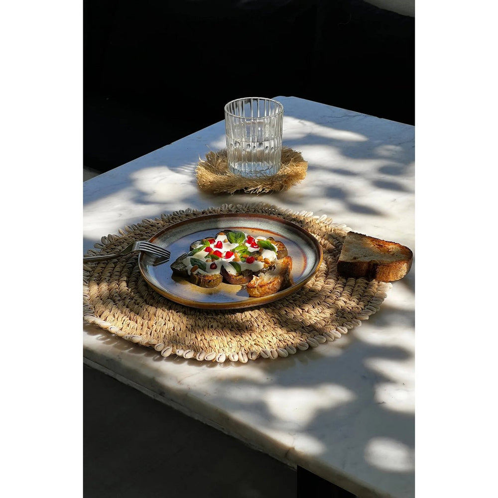Natural raffia placemat with cowrie shells