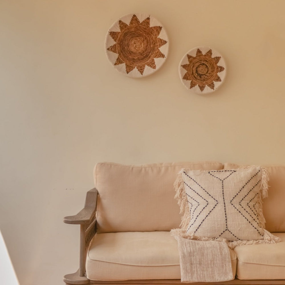Beige sofa with decorative pillow and wall art in a living room setting
