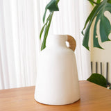 White clay vase with rattan-wrapped handle