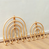 Set of wicker coat hangers on a wooden floor against a white wall