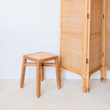 Brown wooden stool with woven rattan seat