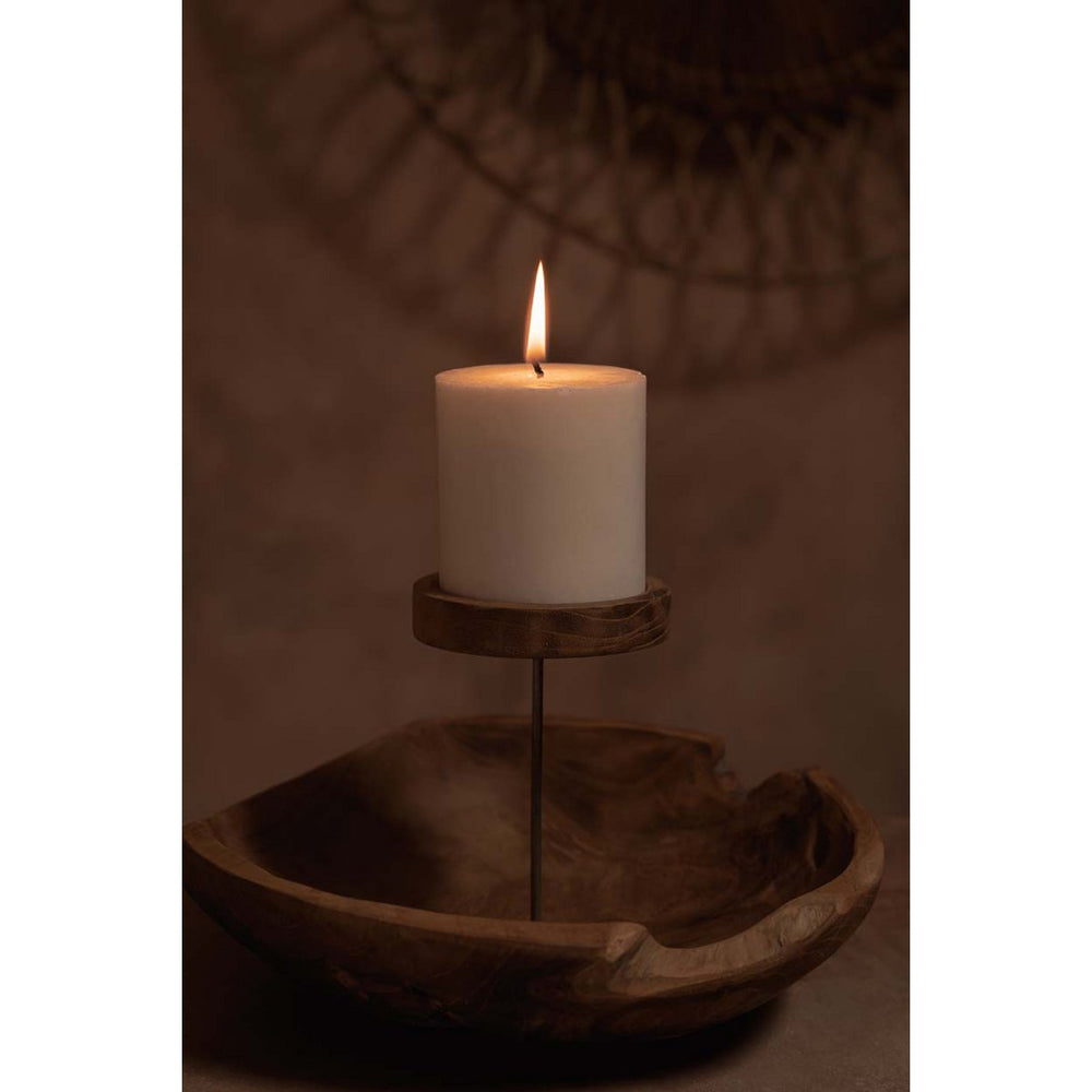 White candle on a wooden stand with a dark background