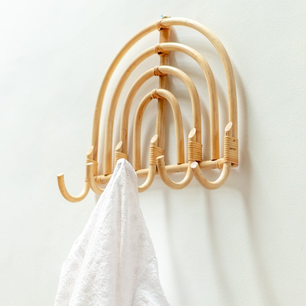 Bamboo wall hook with multiple hooks on a white wall, holding a white towel.