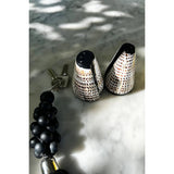 Black beaded keychain with textured metal ends on a marble surface