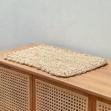Woven mat on a wooden surface with a neutral background