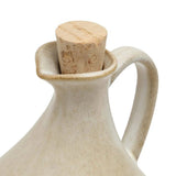 Beige ceramic bottle with cork stopper on a white background