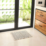 Striped rug on a light-colored floor with a wooden cabinet and glass doors in the background.