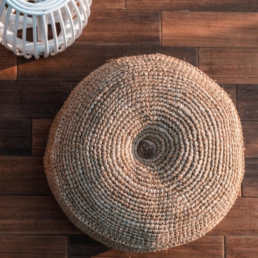 Round woven ottoman on a wooden floor