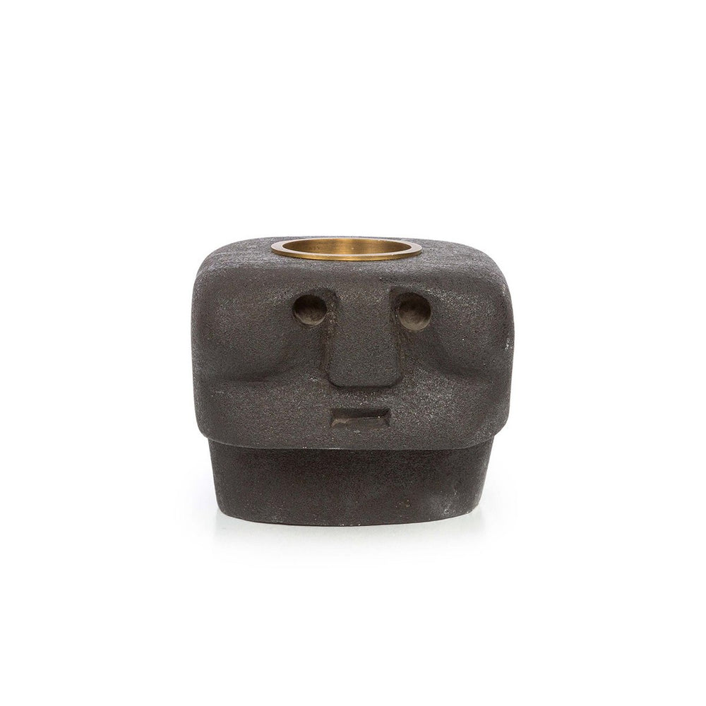 Ceramic face-shaped candle holder with a brass interior on a white background
