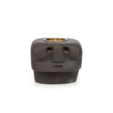 Ceramic face-shaped candle holder with a brass interior on a white background