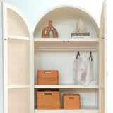 Open wardrobe with wicker baskets, clothes, and decorative items on shelves.