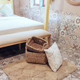 Bedroom with woven baskets, rug, and patterned wall tiles.