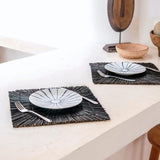 Black seagrass placemat with radial woven pattern